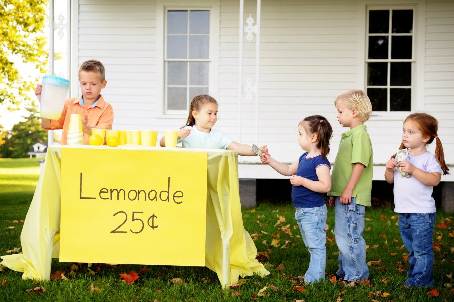 children standing in line at a lemonade stand